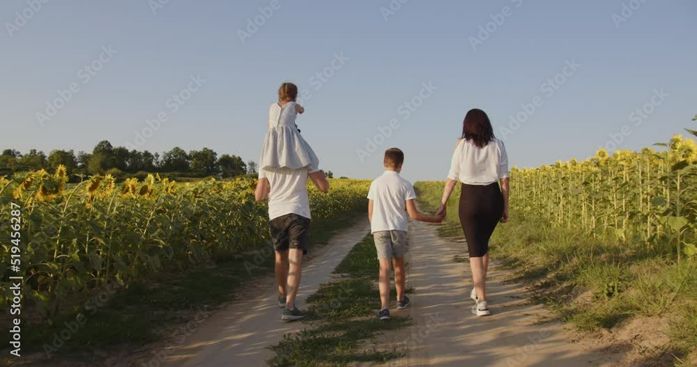 A family with two children walks in nature on a sunflower field A family with two children walks in nature on a sunflower field