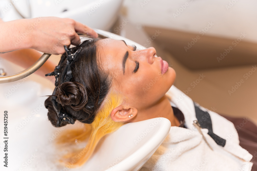 Fototapeta premium Hairdresser cleaning the hair with hot water and soap to a client