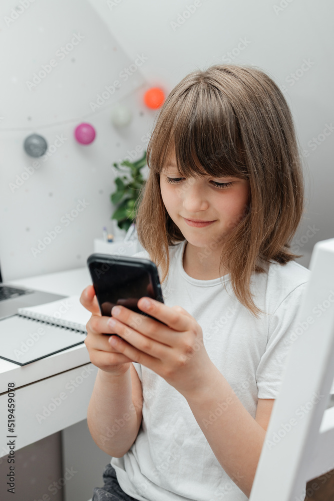 A teenage girl sits in her room and uses a mobile phone, writes or reads a message, makes a video call. Teenagers and the Internet A teenage girl sits in her room and uses a mobile phone, writes or reads a message, makes a video call. Teenagers and the Internet