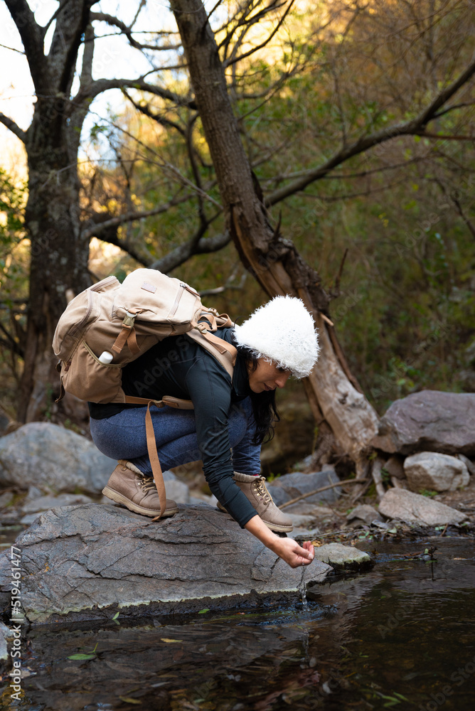 Naklejka premium woman in mountain and forest with hat and backpack autumn afternoon 