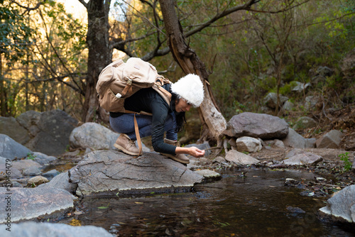 woman in mountain and forest with hat and backpack autumn afternoon
 photo