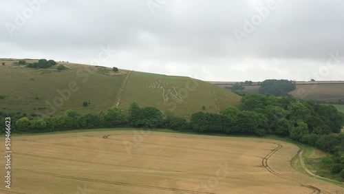 4k aerial video of The Cerne Abbas Giant is a hill figure near Cerne Abbas in Dorset, England. 55 metres high, standing nude male with a prominent erection and wielding a large club in its right hand photo