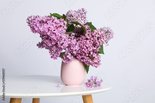Beautiful lilac flowers in vase on white table