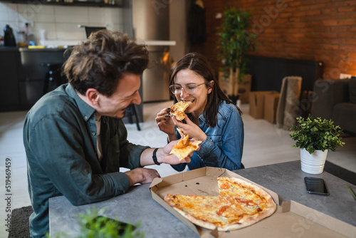 Young couple man and woman modern caucasian friends eat pizza at home