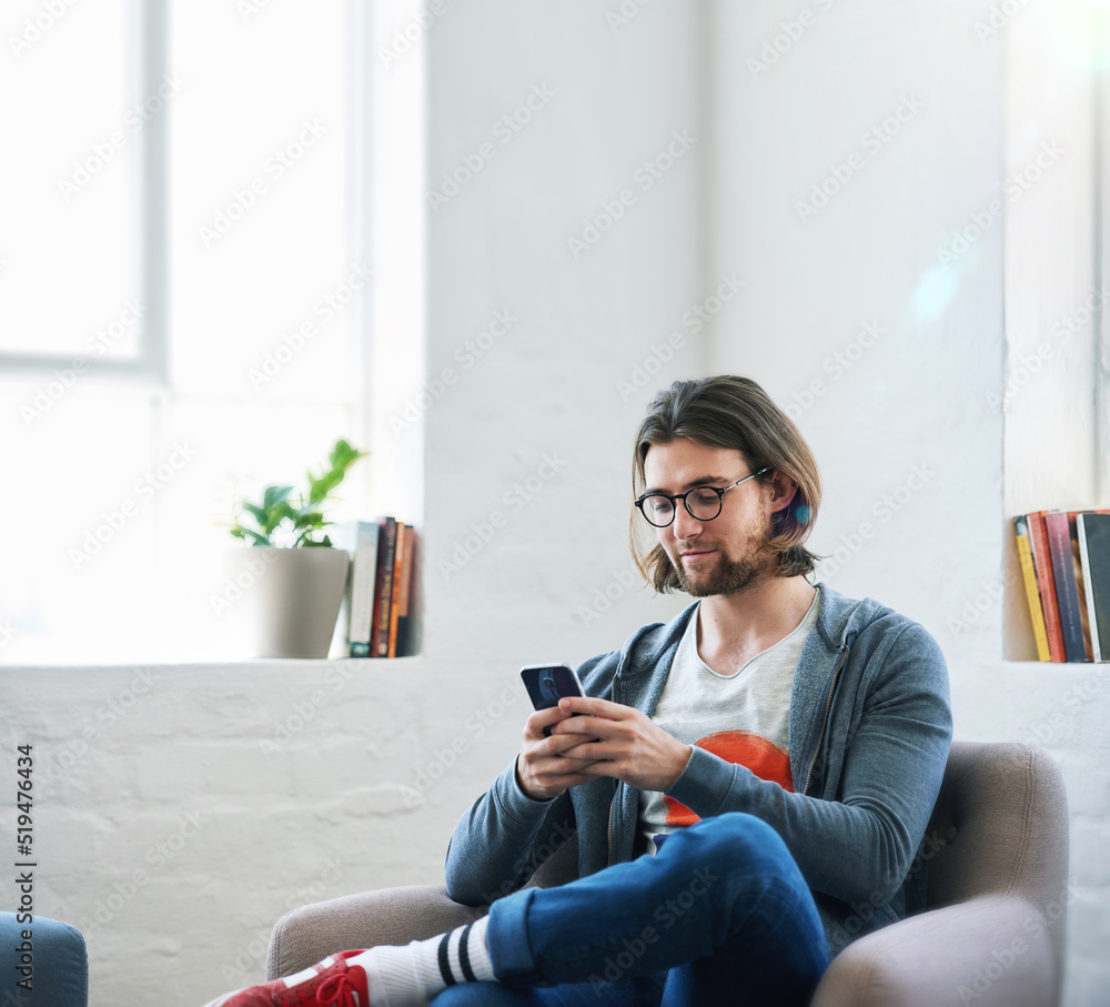 Young man using smartphone at home texting reading social media messages browsing online Young man using smartphone at home texting reading social media messages browsing online