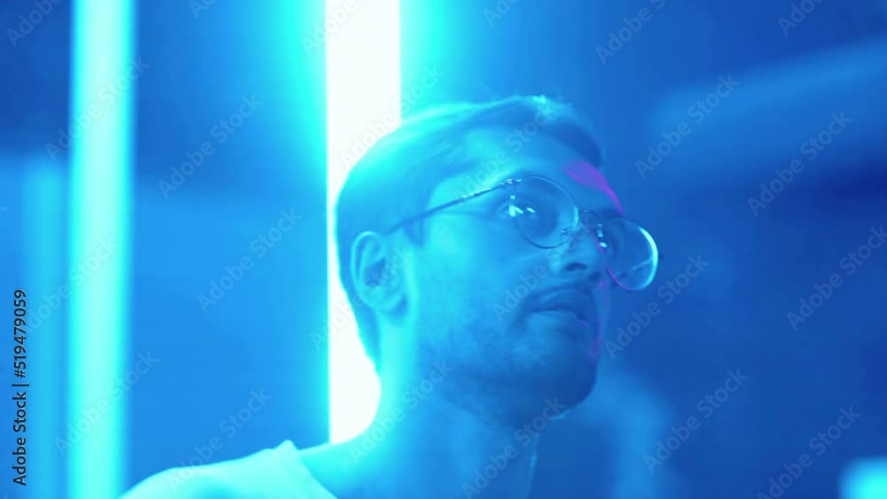 Close-up of a young man dancing in a nightclub under a neon light. Night club Close-up of a young man dancing in a nightclub under a neon light. Night club