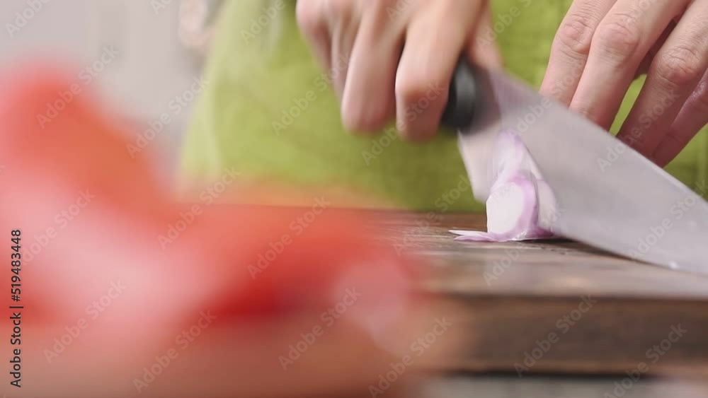Cutting red onion on a wooden cutting board, slow motion.
Cutting red onion on a wooden cutting board, slow motion.