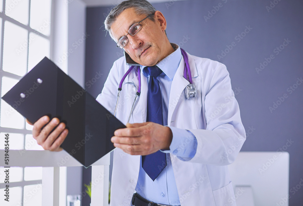 Male doctor writes notes on the clipboard in the hospital Male doctor writes notes on the clipboard in the hospital