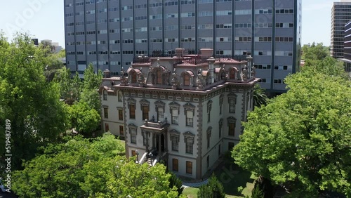 Wide reverse pullback aerial shot of the Stanford Mansion in Sacramento. 4K photo