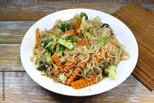 Traditional fried rice noodle mixed with fresh vegetable serving on the plate. Famous street food menu in Asia restaurant. High fiber and low fat recipe.
