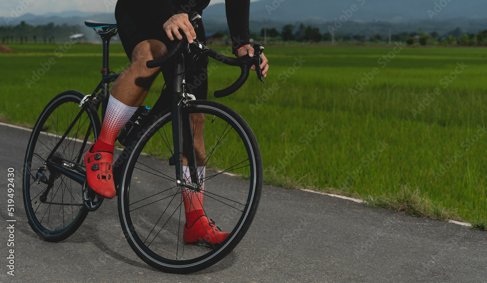 Front view of professional cyclist in cycling training suit against green nature blur background Healthy fitness and lifestyle concepts Front view of professional cyclist in cycling training suit against green nature blur background Healthy fitness and lifestyle concepts