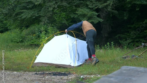 man disassembling tent at a campsite 4K photo