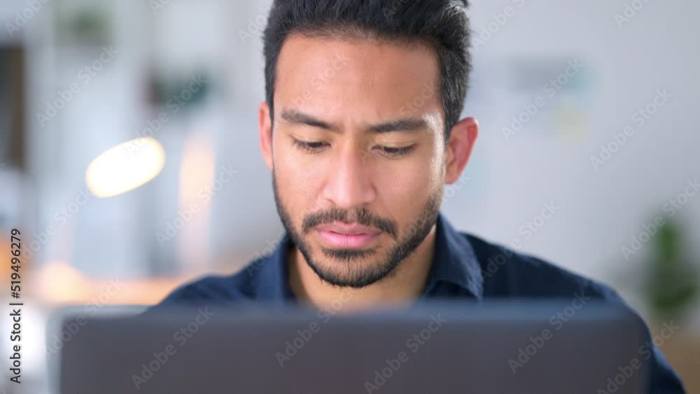 Focused, concentrating and thinking business man reading information on a laptop and working on a task at work. Young male entrepreneur sending an email, typing a reply and trying to meet a deadline