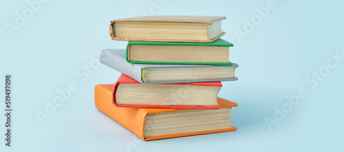 Stack of books on light blue background