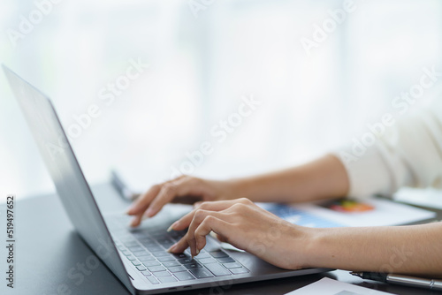 Close-up of business woman typing on his laptop computer in the office.