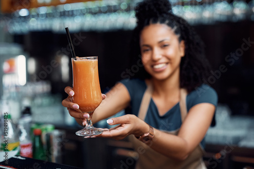 Close up of waitress holding glass of fresh fruit juice. photo