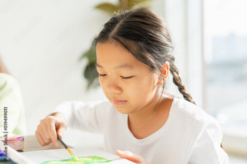 beautiful young children serious painting color, look at paper, hold paintbrush in education classroom. asian beautiful children happy and fun color painting education in small school beautiful young children serious painting color, look at paper, hold paintbrush in education classroom. asian beautiful children happy and fun color painting education in small school