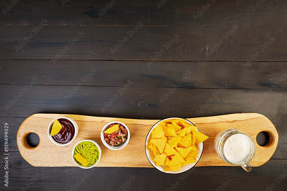 Mexican nachos with cheese. Corn chips with guacamole, salsa and tomato ketchup. Mexican nachos with cheese. Corn chips with guacamole, salsa and tomato ketchup.