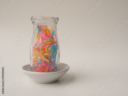 colorful rubber band in a small bowl with a white background. Rubber bracelet.