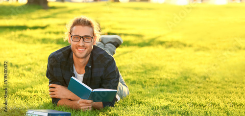 Handsome man reading book i...