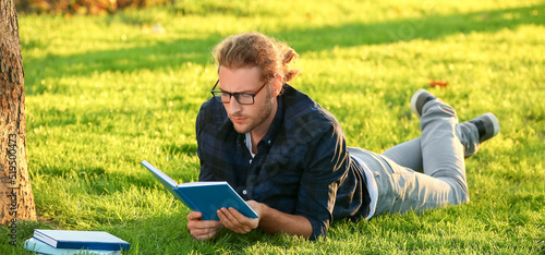 Handsome man reading book i...