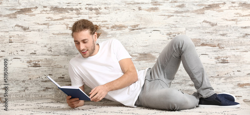 Handsome man reading book n...