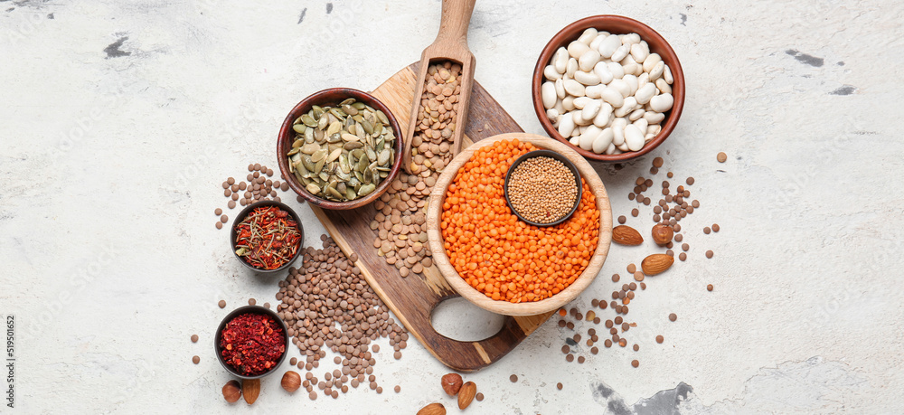 Bowls with raw legumes and spices on light background Bowls with raw legumes and spices on light background