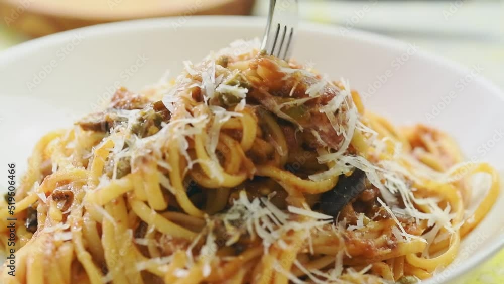 Eating pasta alla norma, served in a plate.
Eating pasta alla norma, served in a plate.