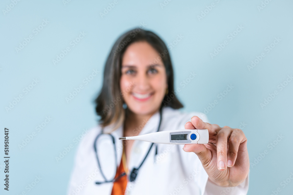 Latin woman doctor Close up holding thermometer isolated over blue color background in Latin America Latin woman doctor Close up holding thermometer isolated over blue color background in Latin America