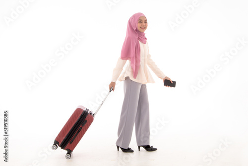 Beautiful young muslim woman holding mpbilephone and taking suitcase, baggage isolated on white background. Concept of traveling, business travel, confidence, woman working