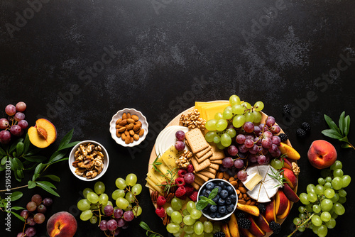 Fototapeta Naklejka Na Ścianę i Meble -  Autumn cheese board with fresh fruits and berries served with white wine, top view
