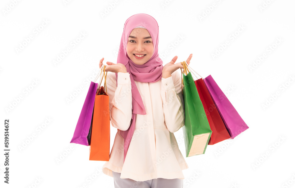 Beautiful and smiling young muslim woman holding colorful shopping bags aisolated on white background. Concept of lifestyle, shopping, enjoy life