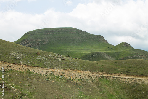 Dramatic landscape - steep cliffs and green hills with cloudy sky and fog on a summer day in the Elbrus region North Caucasus russia and soft blurred focus