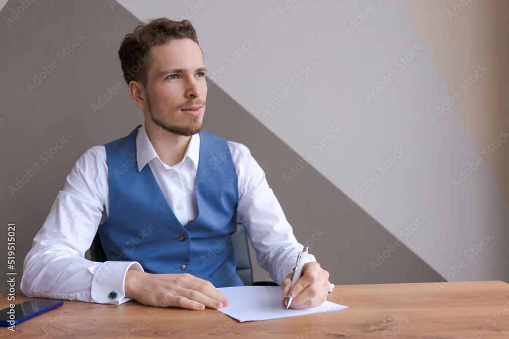 Young businessman with beard sits in office at table with documents and thinks about successful signing deal and the conclusion contract. Interview or discussion of plans for business development Young businessman with beard sits in office at table with documents and thinks about successful signing deal and the conclusion contract. Interview or discussion of plans for business development