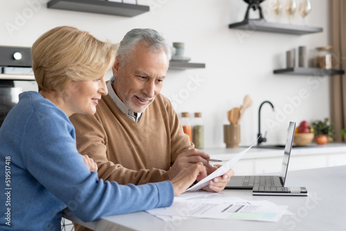 Mature family couple check utility bills together