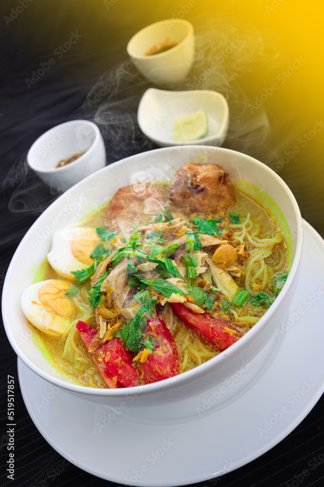 INDONESIAN CULINARY CHICKEN SOUP NOODLE WITH SLICE BOILING EGG AND FRIED MASHED POTATOS AS TOPPING