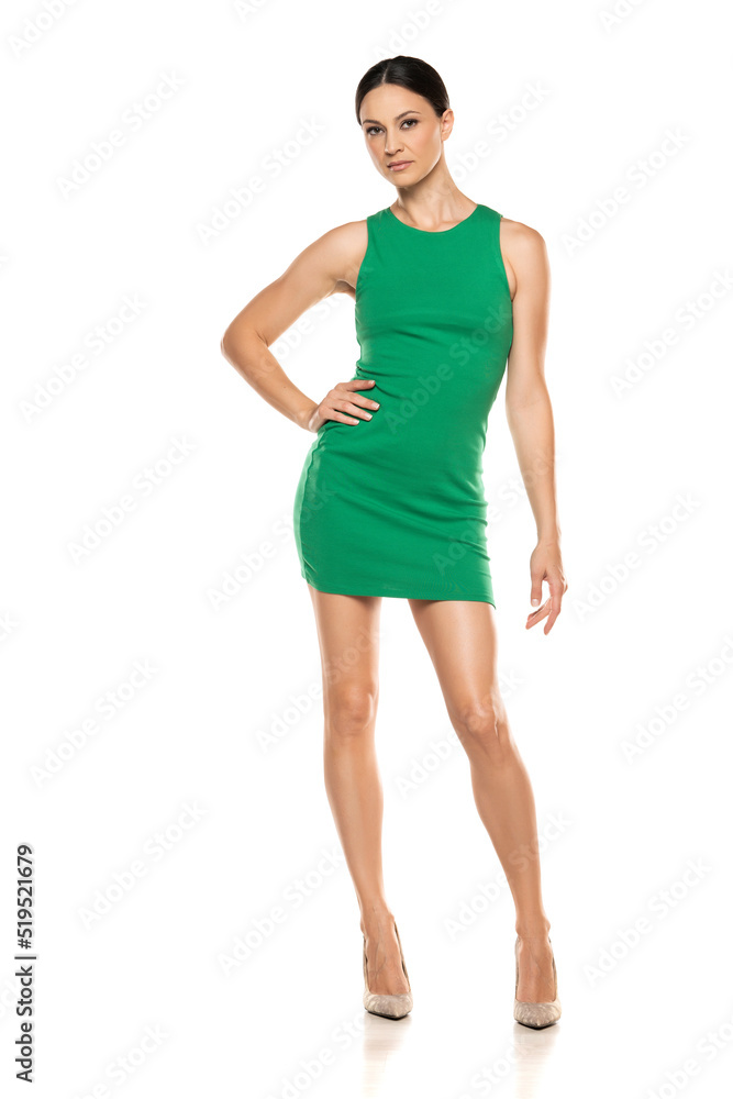 a young woman in a short green dress posing on white background a young woman in a short green dress posing on white background