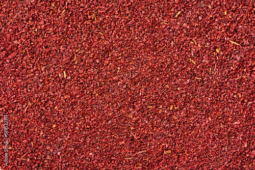 Ground sumac spice powder background. photo