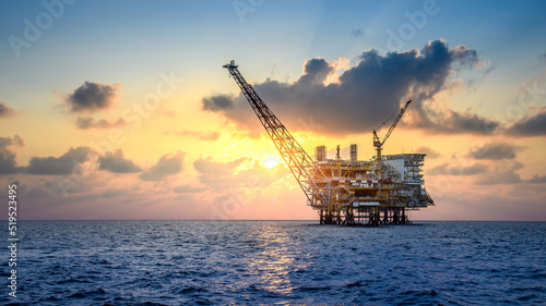 Foto Offshore oil and rig platform in sunset or sunrise time
