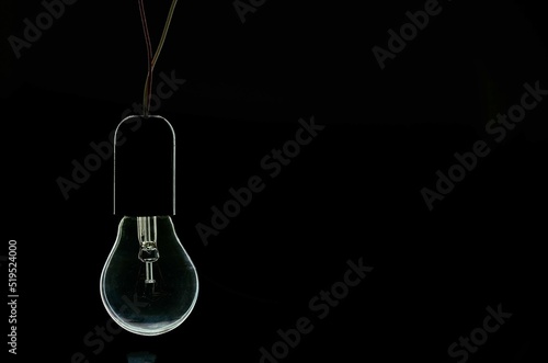 turned off incandescent light bulb on a black background