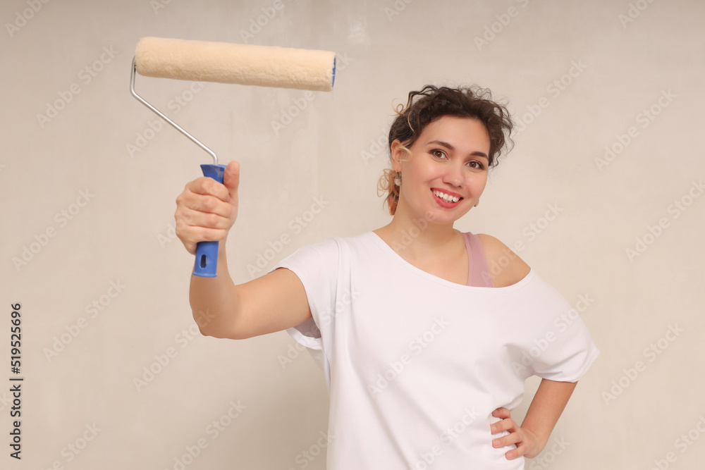 Happy beautiful young woman holding a roller Happy beautiful young woman holding a roller