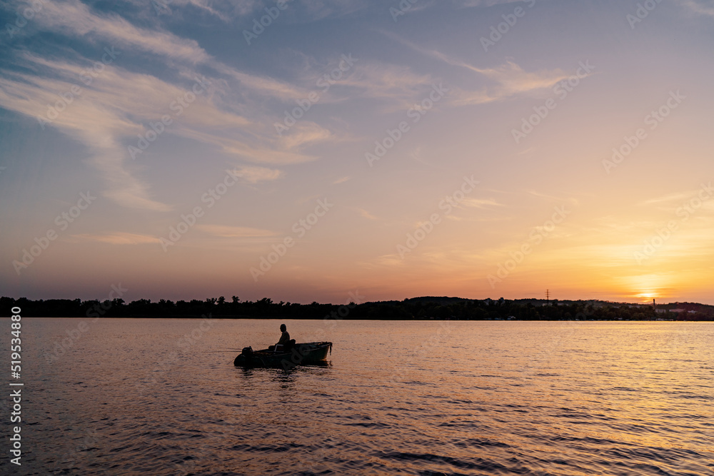 Fishing boat over beautiful sunset background.