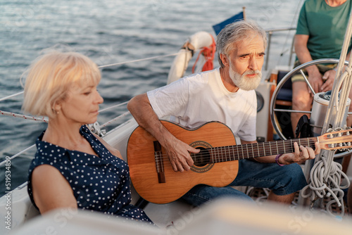 Romantic vacation and luxury travel. Senior loving couple sitting on the yacht deck. Sailing the river. © luengo_ua