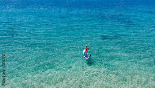 Aerial view of woman riding paddleboard on sea