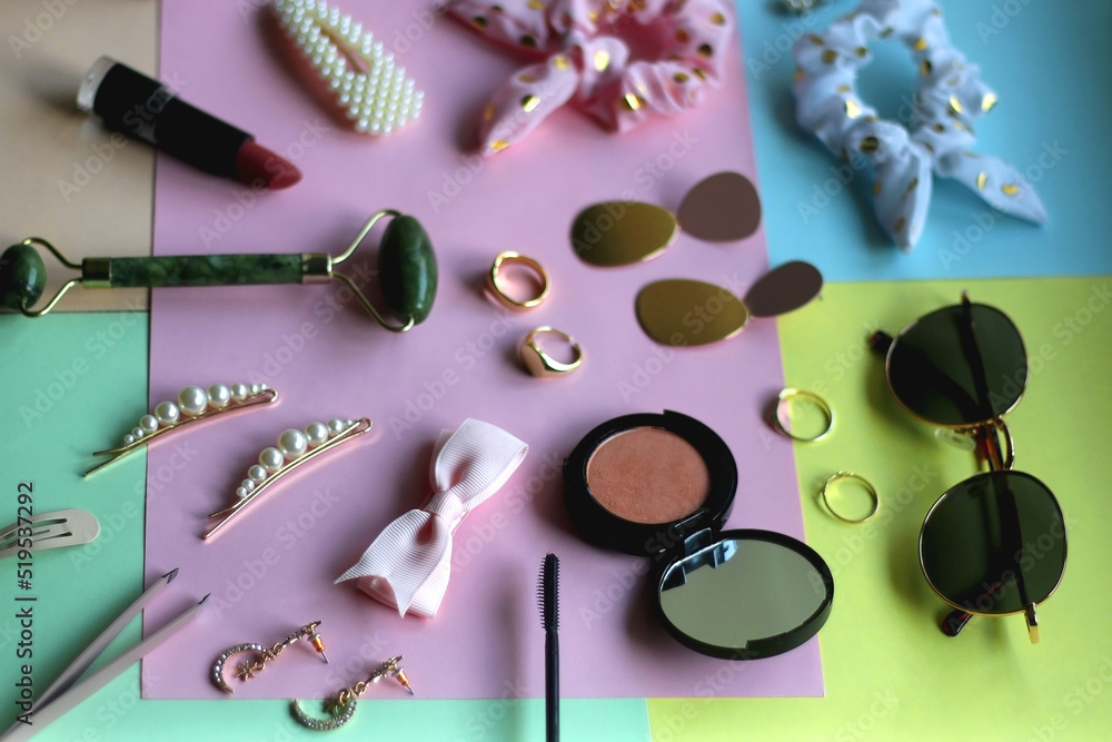 Various accessories, make up products and jewelry on various colorful pastel backgrounds. Selective focus. Various accessories, make up products and jewelry on various colorful pastel backgrounds. Selective focus.