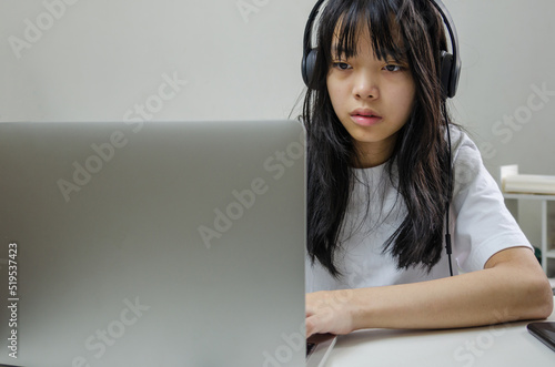 Wallpaper Mural girl wearing headphones studying online with computer laptop and listen to relaxing music or play internet social media at home. Torontodigital.ca