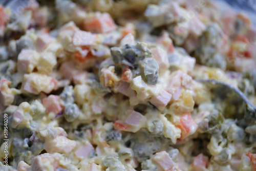 Olivier salad and food ingredients green peas cucumber potatoes sausage and mayonnaise