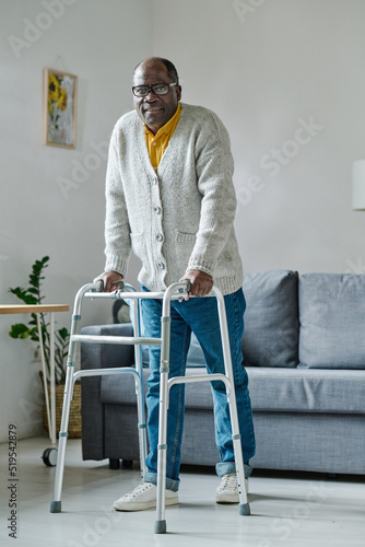Fotografija Portrait of African mature man trying to walk with walker during his rehabilitat