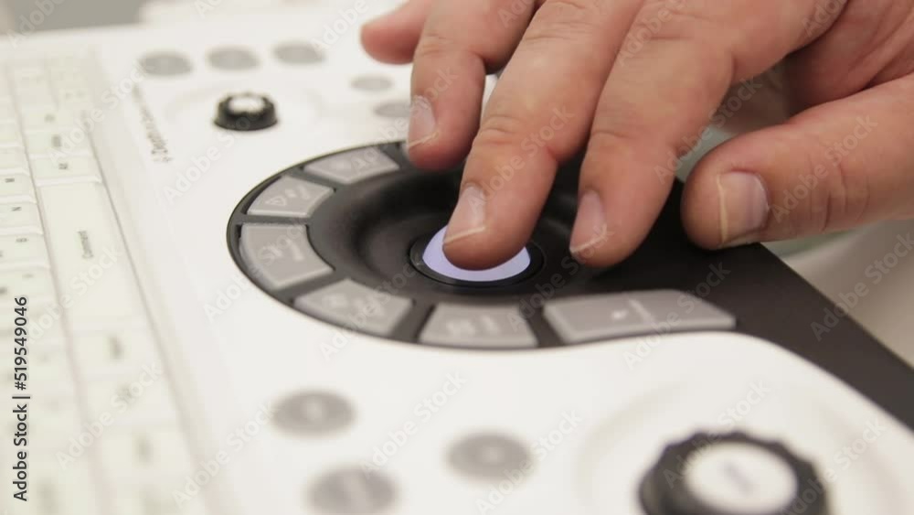 Close-up of hands of doctor working on ultrasound device in medical clinic Close-up of hands of doctor working on ultrasound device in medical clinic