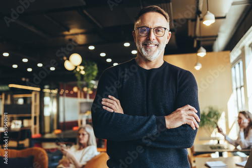 Mature businessman standing in a co-working space photo